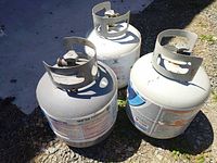 Top view of three propane cylinders showing collars and valves