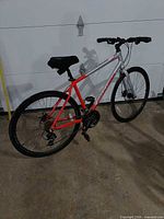 Full view of Schwinn red and silver hybrid bicycle, showing wheels, handlebars, drivetrain and brakes