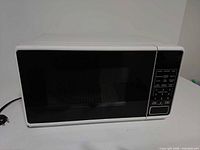 Front view of white 700W microwave with black door and control panel