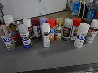 All fourteen cans lined on table