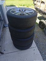 Stack of four Subaru alloy wheels with tires