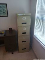 full view of gold metal 4-drawer cabinet beside desk