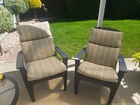Both plastic Adirondack chairs with cushions on patio