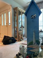Full view of painted birdhouse with surrounding items