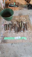 Top view of entire assortment of chisels and punches laid on plywood board