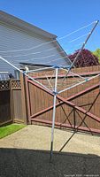Full view of standing rotary clothesline showing aluminum pole, folding arms and lines