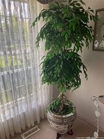 Full view of artificial ficus tree in planter by window