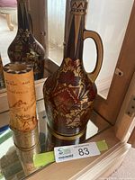 Full view of both decor pieces: painted jug carafe and wooden pyrography vase