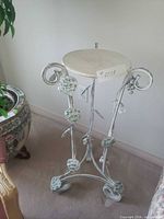 full view of iron plant stand showing scroll legs and ivy leaves