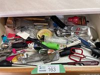 Full drawer view showing large quantity of assorted utensils
