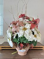 Full view of artificial poinsettia arrangement in terracotta vase
