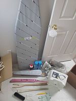 Overall lot showing ironing board, bucket, starch cans, sleeve board, brush and accessories
