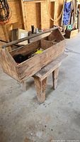 Full view of wooden tote on small stand, shows overall size and wear