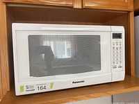 Front view of Panasonic microwave on shelf
