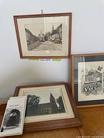 Group shot of three framed artworks and booklet