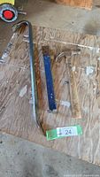 Full view of crowbar, lifter bar, and hammer on wood surface