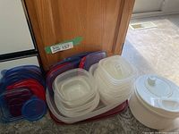 Group of stacked food storage containers with lids and salad spinner
