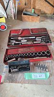 Overview of three socket sets in red metal and black plastic cases
