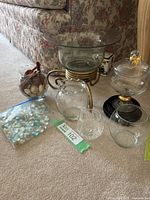 Group shot of all glass items including bowl on metal stand, candy dish, rose vases, crystal votive and bead bag