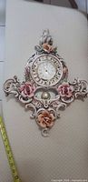 Front view showing full ornate porcelain clock with floral details