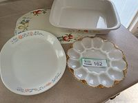 Overall lot showing lasagna pan, oval platter, egg plate, and placemat beneath
