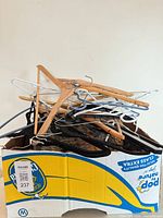 Box containing assorted wooden, plastic, metal, and felt clothing hangers