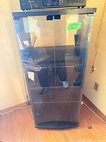Front view of black media cabinet with smoked glass doors