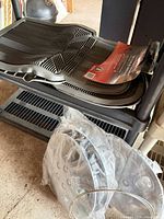 Stack of rubber mats on shelf beside bagged wheel covers