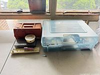 Overall view of blue tackle box and red case on table