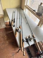 All six fishing rods laid out on table showing overall condition and which have reels