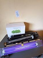 Group showing Blacklite Bolt fixture, two additional fluorescent fixtures, spare tube, Smart Garden box