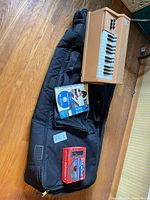 Overview showing Gator gig bag, National organ keyboard, harmonica kit box, manuals