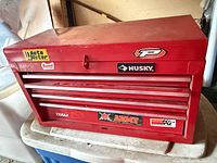 Front view of red Husky toolbox showing drawers, stickers, latch