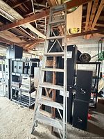 Aluminum ladder with wooden ladder nested behind, full view