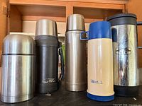 Five thermoses lined up showing sizes and finishes