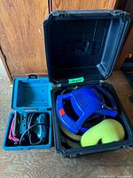 Open cases displaying Makita sander and Simoniz polisher with accessories