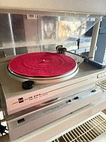 Dual CS 616 Q turntable on a shelf above Sansui unit, dust cover raised