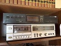 Front view of both audio components stacked on shelf