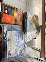 All three packaged tarps on table