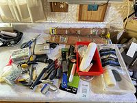 Countertop view showing assorted tools, hardware boxes and four wooden hook racks