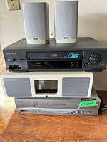 Stack of two VCRs, Bose SoundDock, pair of Aiwa speakers