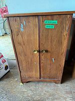 Front view of wooden cabinet with two doors and brass knobs