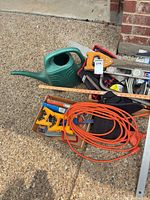 Grouped view showing watering can, extension cord, hand saw handle, levels, tool bag, box of clamps