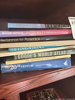 Stack of nine oversized hardcovers, spines visible for title identification