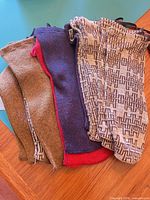 Stack of five knit scarves/leg warmers in assorted colours