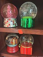 Shelf view showing all four Neiman Marcus snow globes
