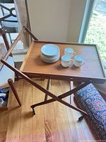 wood tray on folding stand with china set displayed