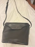 Front view of black leather Salvatore Ferragamo bag with flap closed