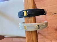 Black and beige headbands on chair back showing top view and logo hardware