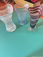 All three ribbed glass vases showing color variations, shapes and pedestal bases